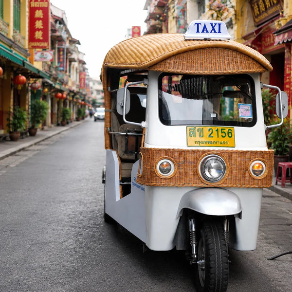Classic tuk tuk on a colourful Yaowarat shophouse street in Bangkok Chinatown