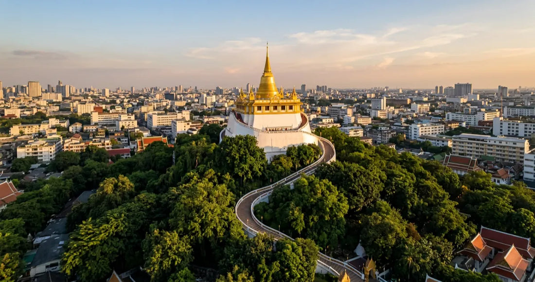 Aerial view of the Golden Mount and Wat Saket at sunset with Bangkok skyline
