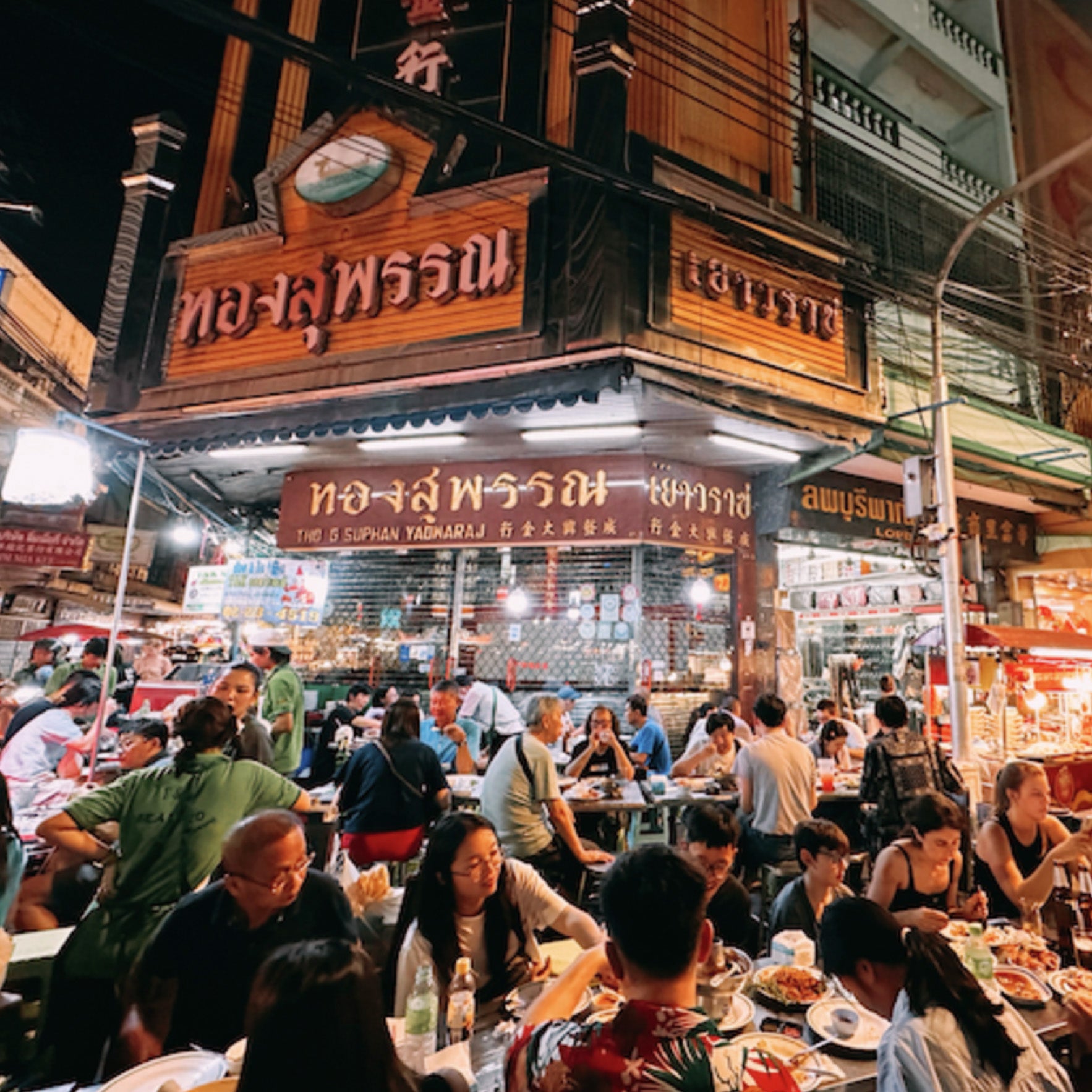 Crowded night food market in Bangkok Chinatown, enjoy lively street dining with TukMe Tuk Tuk tours
