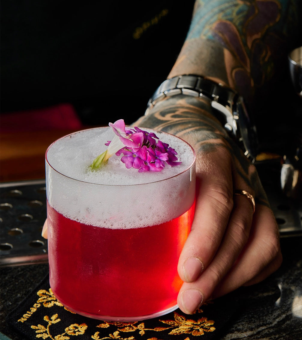 Artisan craft cocktail with floral garnish at Bangkok speakeasy on TukMe tuk tuk bar hopping tour