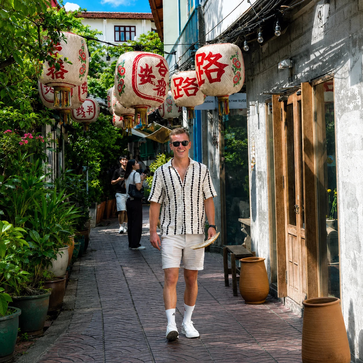 Traveler walking past traditional Chinese lanterns in a Songwat alley, Bangkok Chinatown, on a TUK ME tuk tuk tour